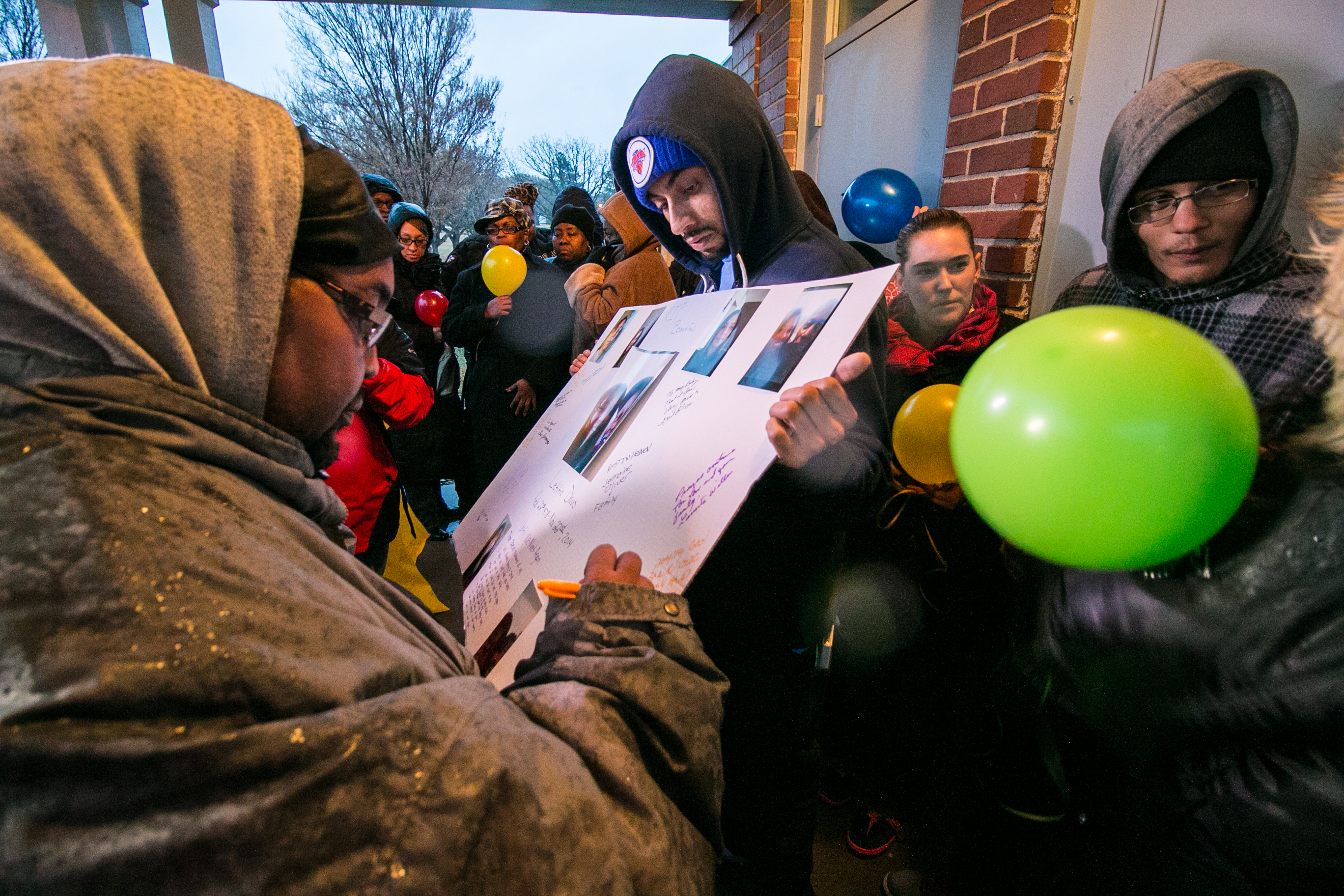 Friends and family sign a poster board in Letitia Davis's memory Sunday. (Photo by Kevin Brown)